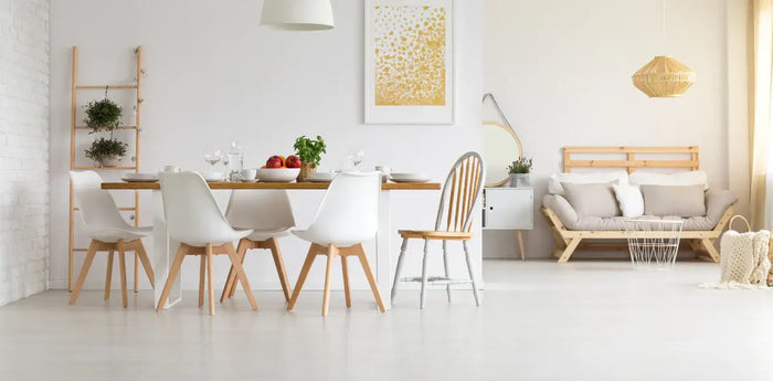 Minimalist dining and living area with modern furniture, white walls, and natural light in a home improvement setting.