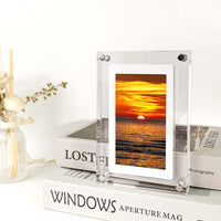 Digital Picture Frame Acrylic Video Player displaying sunset on a white bookshelf with decorative items.