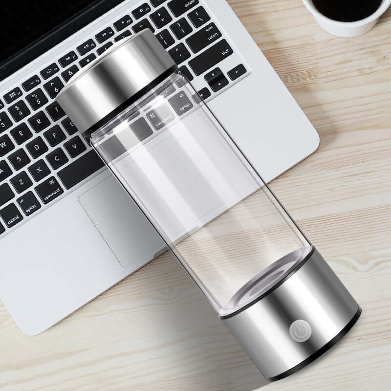 Upgraded Health Smart Hydrogen Water Cup on wooden table near laptop.