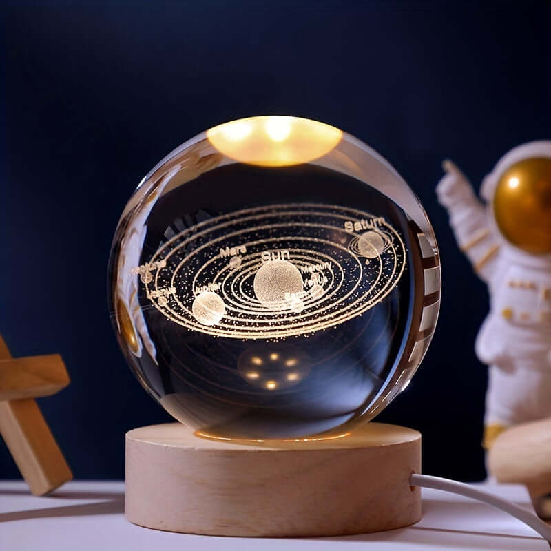 3D Solar System Crystal Ball Night Light on wooden base, featuring a laser-engraved solar system, with an astronaut in the background