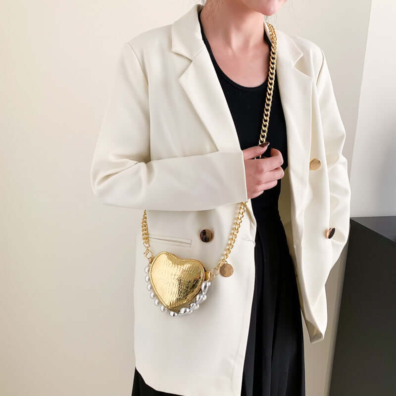 Woman wearing a white blazer with black shirt holding a Mini Love-Shape Pearls Handbag, showcasing its cute and functional design.