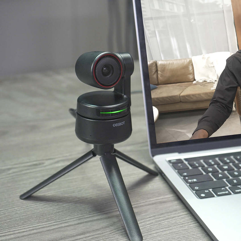 OBSBOT Tiny 4K AI PTZ Webcam on a tripod connected to a laptop for high-quality video conferencing and professional presentations