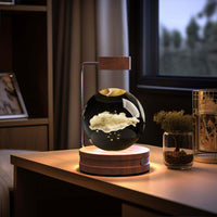 Crystal Ball Cosmic Dinosaur Indoor Night Light USB Power Warm Bedside Lamp on a wooden table in a cozy bedroom.