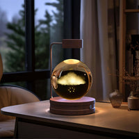 Crystal Ball Cosmic Dinosaur Indoor Night Light USB Power Warm Bedside Light Birthday Gift Night Lamp on a wooden table by the window.