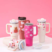 Colorful 40 Oz insulated tumblers with handles, featuring cute heart designs and a straw, perfect for keeping beverages hot or cold.