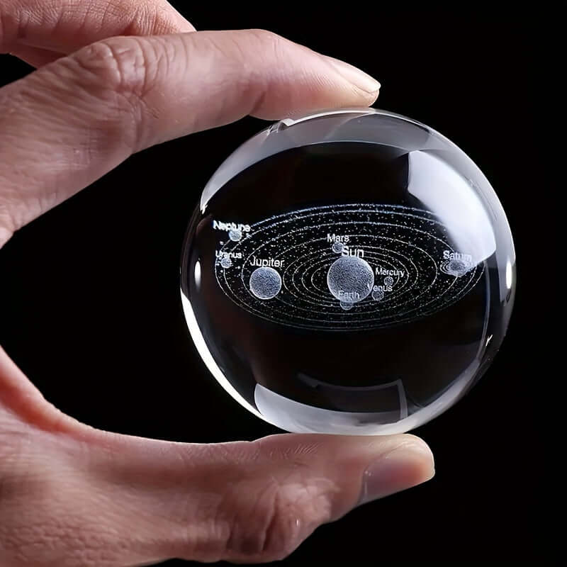 Hand holding a 3D Solar System Crystal Ball Night Light showcasing an intricate laser-engraved image of the solar system.