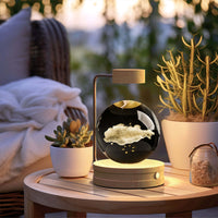 Crystal Ball Cosmic Dinosaur Indoor Night Light on a wooden table, creating a warm romantic atmosphere with succulents and cozy bedding nearby.