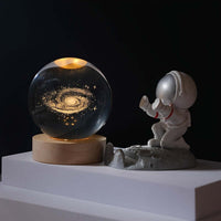 3D Solar System Crystal Ball Night Light next to an astronaut figurine, perfect for igniting children's curiosity and imagination.